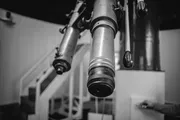 Close-up of a vintage observatory telescope, photographed in black and white.