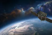 Artwork of a satellite with twin solar panels above Earth against a colourful nebula and star field.