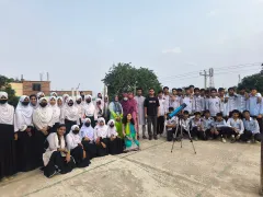 Durbin volunteers and the students of Nagarbari Maritime School and College gathered around a telescope for a group photo.