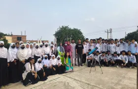Durbin volunteers and the students of Nagarbari Maritime School and College gathered around a telescope for a group photo.