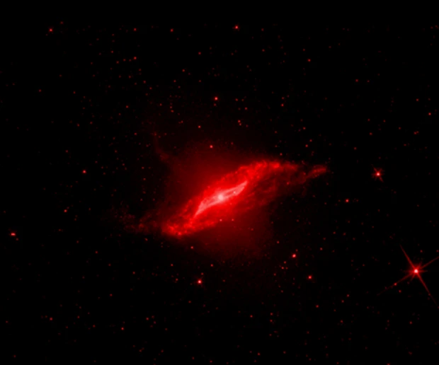 Centaurus A in infrared light (Spitzer): Warm dust — piercing the haze to reveal the warped disk left by an ancient galaxy merger.